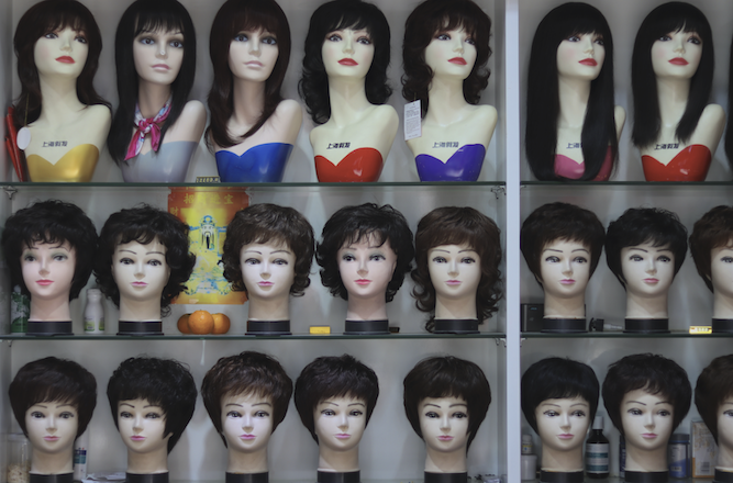 Window display of variety of wig styles